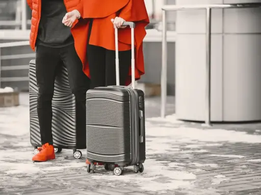 Två personer med resväskor, redo för flygresan med easyjet handbagage.