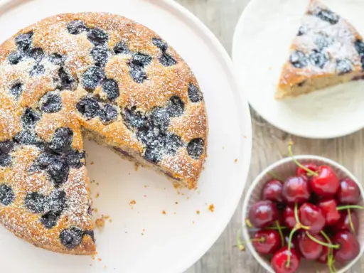 Saftiger Kirschkuchen, bestäubt mit Puderzucker. Ein köstliches kirschkuchen rezept für den Sommer.