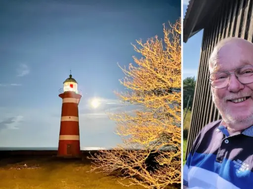 Rött och vitt fyr på Gotland i månsken, bredvid ett träd med gyllene löv. Till höger en glad man med glasögon.