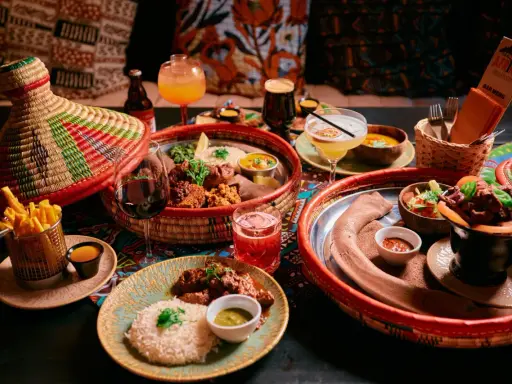 En härlig måltid på en afrikansk restaurang med flera rätter, drycker och en färgglad duk.