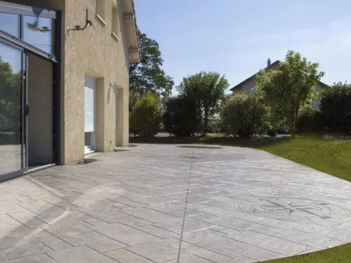 Terraza de hormigón impreso con diseño de brújula, mostrando cómo se hace el hormigón impreso para un acabado elegante y duradero.