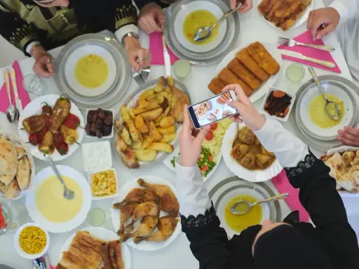 Festliches Zuckerfest Essen wird fotografiert. Ein reich gedeckter Tisch mit Suppe, Hähnchen, gefüllten Paprika und Brot.