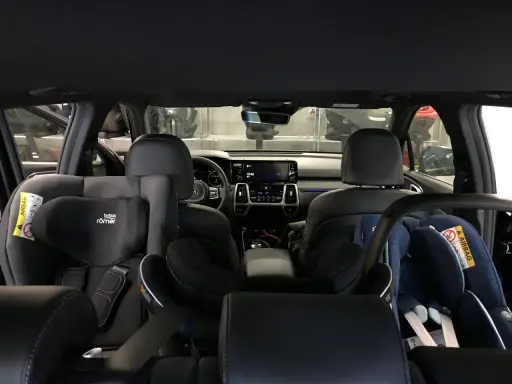 Wnętrze samochodu z dwoma fotelikami dziecięcymi. Z tyłu widać 3 isofix, gotowe na podróż z najmłodszymi.