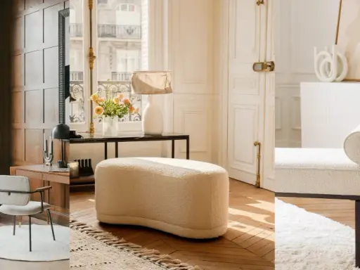 Comode poltrone al posto del divano, in un elegante salotto con parquet e grandi finestre.