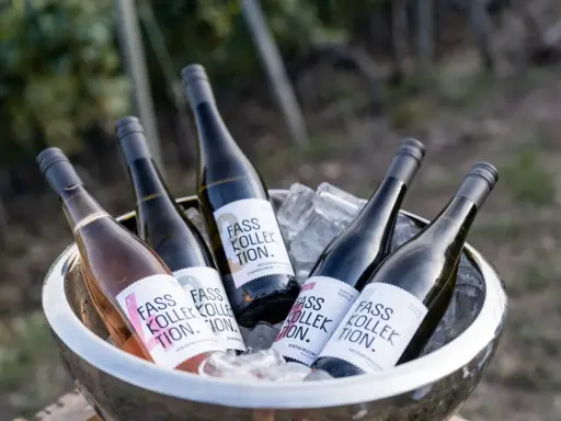 Flaschen mit "Fass Kollektion" Etiketten, darunter ein Rosé-Wein, in einem Eisbehälter. Ein Genuss für Liebhaber von gutem **Wein rot** und weiß.