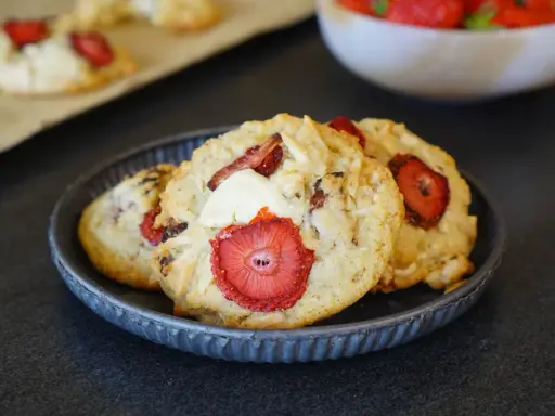 Trois cookies gourmands aux fraises et éclats de chocolat blanc, parfaits pour une pause sucrée.