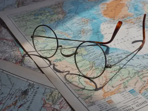 Okulary na mapie świata, planowanie wakacji w listopadzie gdzie najcieplej.
