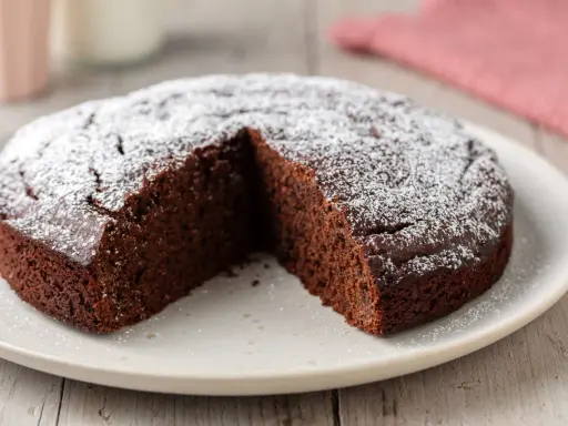 Una deliziosa torta al cioccolato, spolverata di zucchero a velo, con una fetta mancante, pronta per essere gustata.