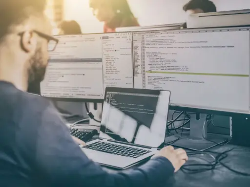 Programista analizuje kod, testując różne rodzaje testów manualnych.