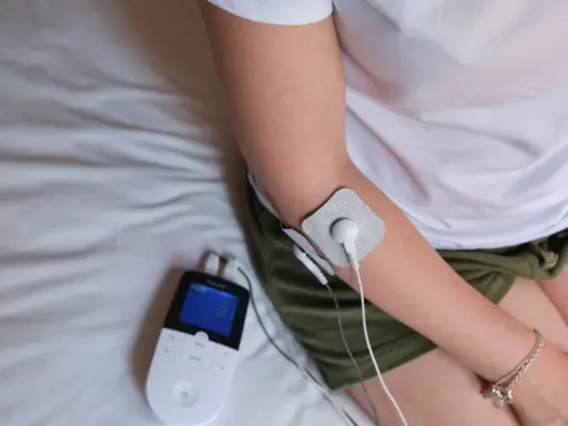 Traitement d'une épicondylite, maladie professionnelle, avec un appareil d'électrostimulation sur le bras.