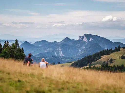 Para odpoczywa po szybkim trekkingu, podziwiając malownicze góry.