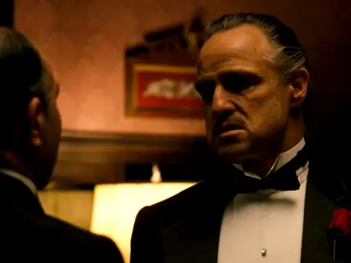 Marlon Brando nei panni di Don Corleone, un'icona de "Il Padrino", in una scena che riassume la sua recensione: potere e dramma.