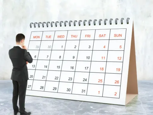 Hombre de traje frente a un calendario, pensando en el **artículo 9 de la LAU** y las fechas importantes.