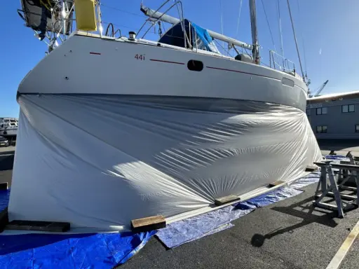 Bateau bâché, prêt pour le sablage de sa coque. Le prix du sablage coque bateau est une étape clé pour sa rénovation.