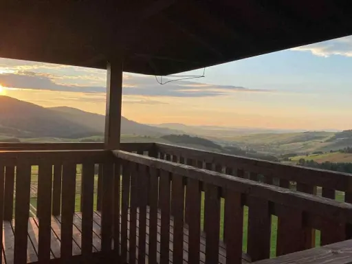 Widok z wieży widokowej na malownicze **beskid niski szczyty** o zachodzie słońca.