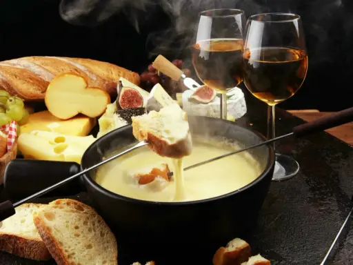 Un délice fumant de fondue au fromage, pain croustillant et vin blanc. Un aperçu des spécialités Auvergne Rhône Alpes.