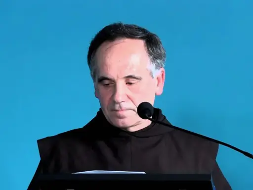 Mężczyzna w habicie przed mikrofonem, czytający psalm 140 tekst.