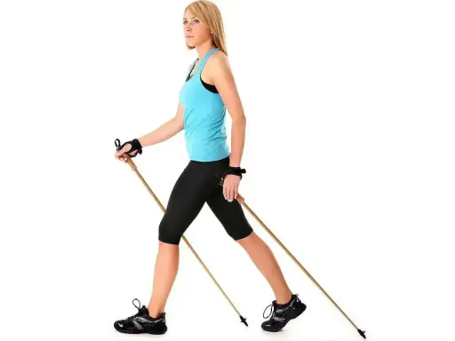 Kobieta w sportowym stroju ćwiczy nordic walking, używając kijków. Dobór odpowiednich kijków do nordic walking to klucz do efektywnego treningu.