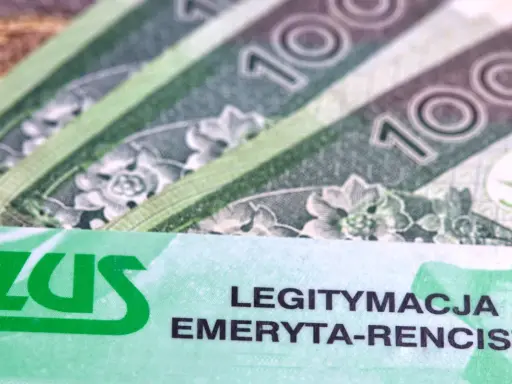 ZUS to Zakład Ubezpieczeń Społecznych. Na zdjęciu widać legitymację emeryta-rencisty oraz banknoty 100 zł.