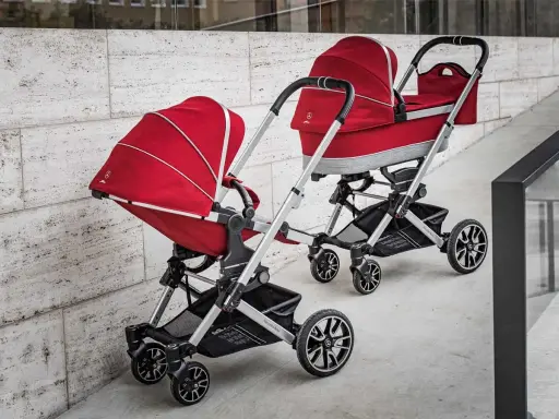 Dwa czerwone wózki dziecięce, eleganckie i stylowe, od renomowanego producenta wózków dziecięcych.
