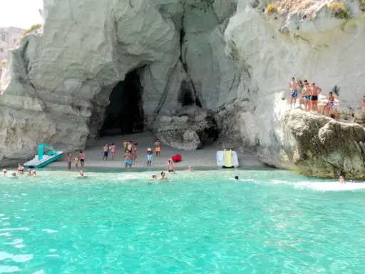 Bambini e adulti si divertono nella grotta del Palombaro, tra scogli e acque cristalline.