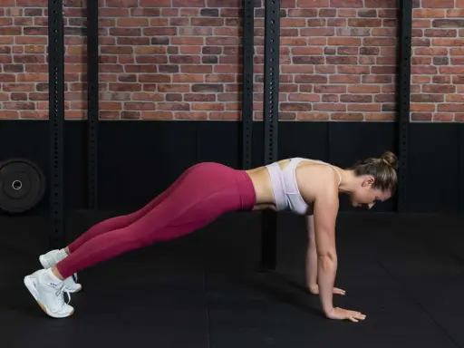 Frau in Liegestützposition, um den Rumpf zu stabilisieren.