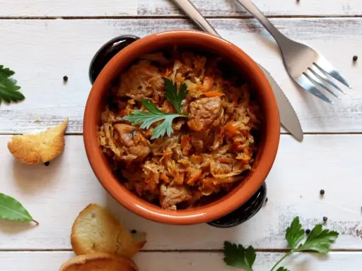 Aromatyczny bigos w glinianym naczyniu, z dodatkiem ziół i pieprzu. Idealne jakie przyprawy do bigosu.
