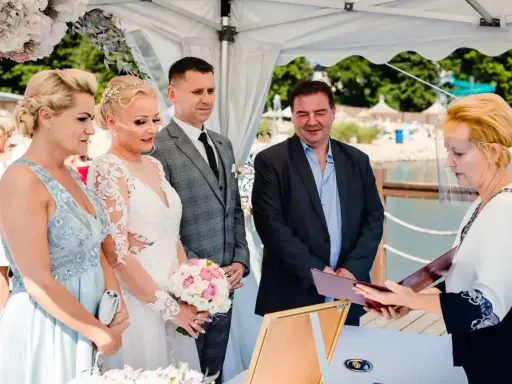 Ślub cywilny po rozwodzie. Para młoda, świadkowie i urzędniczka podczas ceremonii nad wodą.