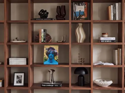 Ideas para decorar una estantería: libros, jarrones, esculturas y plantas crean un espacio acogedor.