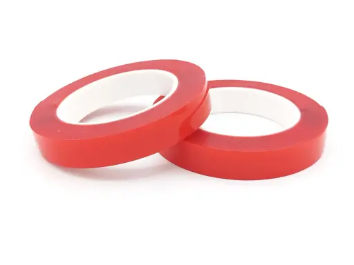 Zwei Rollen rotes Schaumklebeband liegen nebeneinander auf weißem Hintergrund.