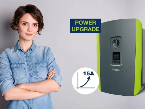 En kvinna med armarna i kors bredvid en KOSTAL Plenticore Plus 10 växelriktare, som symboliserar en "Power Upgrade" med en graf som visar 15A ökning.