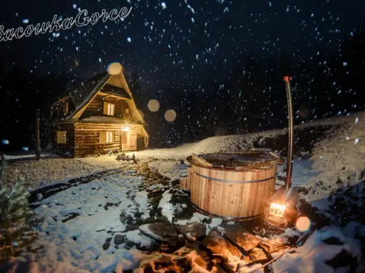 Nocą w bacówce u Winiarskich, przytulny drewniany domek i gorąca balia w śnieżnej scenerii.