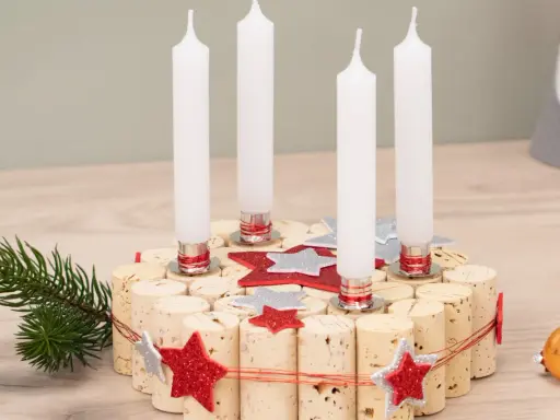 Selbstgemachter Adventskranz aus Korken mit vier Kerzen, Tannenzweig und Glitzersternen. Perfekt zum Adventskranz basteln mit Kindern.