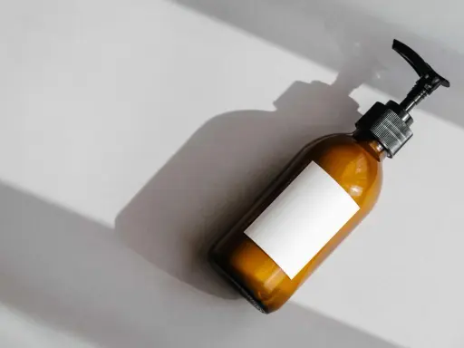 Flacone ambrato con etichetta bianca vuota e dispenser nero. Attenzione agli ingredienti come il cetearyl alcohol fa male.