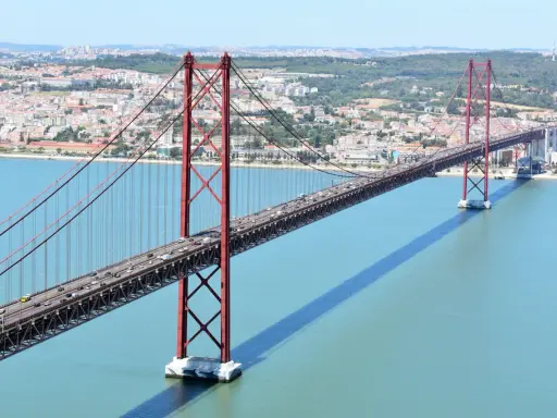 El puente 25 de Abril en Lisboa, con sus icónicas torres rojas, cruza el río Tajo. ¿Cuanto mide el puente de Lisboa? Es un coloso de ingeniería.