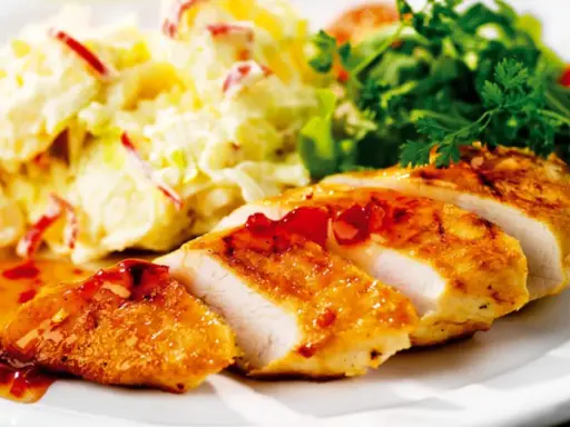 En saftig kycklingfilé serveras med en krämig fransk potatissallad med kyckling och en fräsch grönsallad.