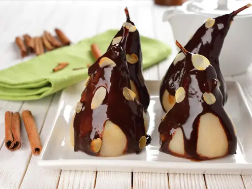 Poires pochées nappées de chocolat noir et d'amandes effilées, une délicieuse recette de poire Belle Hélène.