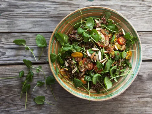 En härlig quinoa sallad med tomater, gröna blad och mandel. Perfekt för ett snabbt och nyttigt quinoa recept.