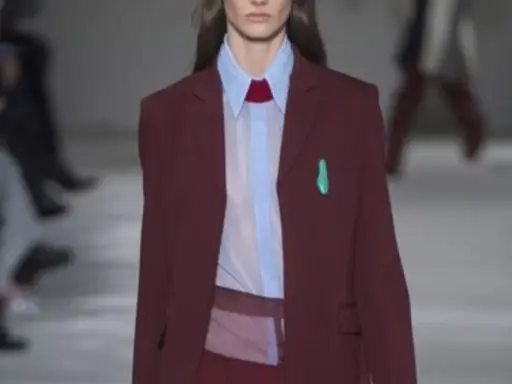 Modella con blazer bordeaux, camicia azzurra e cravatta rossa. Il bordeaux dona un tocco di eleganza sofisticata.