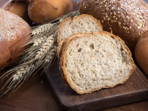 Różnorodne pieczywo, w tym kromki chleba pełnoziarnistego, które sugerują, jakie pieczywo jest dietetyczne.