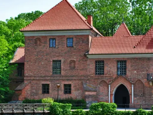 Zamek w Łęczycy, jedna z głównych atrakcji regionu, otoczony zielenią.