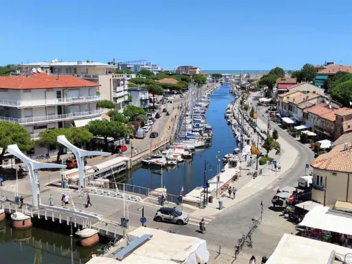 Passeggiata sul canale di Cervia, con barche ormeggiate e negozi. Un'ottima idea per scoprire cosa fare a Cervia in una giornata di sole.