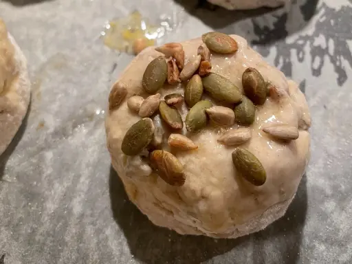 En glutenfri fralla med pumpa- och solrosfrön på en bakplåt.