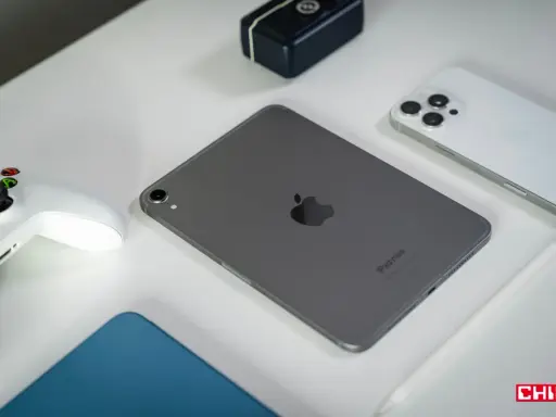 Szary iPad mini, biały kontroler do gier, biały iPhone i rysik na białym tle.