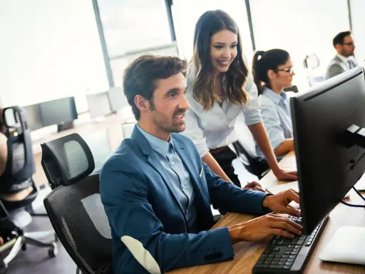 Un equipo colabora en la oficina, mostrando una excelente **comunicación en equipo** mientras trabajan en sus ordenadores.