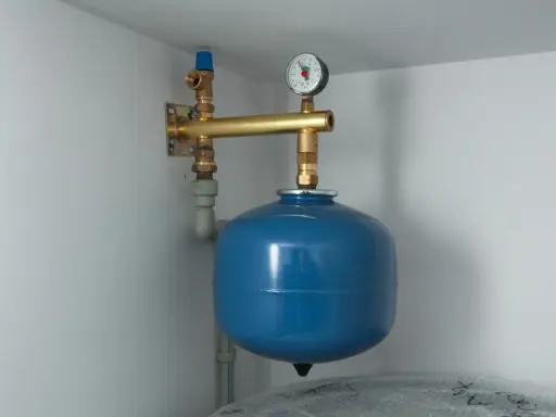 Niebieski zbiornik wyrównawczy co z manometrem, podłączony do instalacji grzewczej.