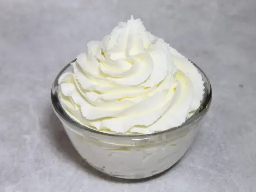Chantilly au robot pâtissier, aérienne et onctueuse, dressée en rosace dans un bol en verre. Parfait pour garnir vos desserts.