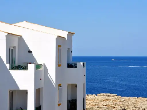 Maison blanche avec balcons face à la mer bleue. Idéal pour un dédommagement location saisonnière.