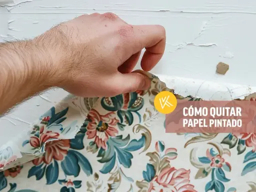 Mano retirando papel pintado floral de una pared blanca.