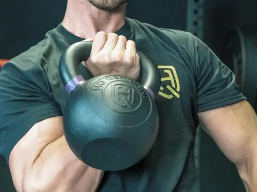 Mann hält Kettlebell, bereit für einen Kettlebell Workout Plan.